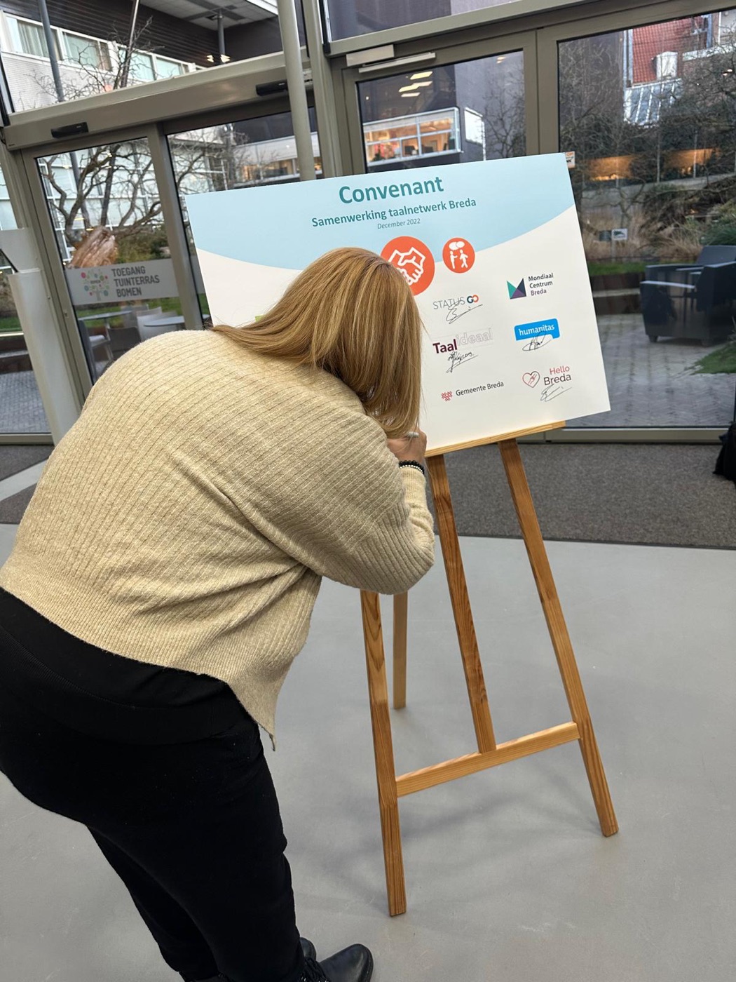 Ondertekening van het convenant op het paneel met de logo’s van de taalpartners
